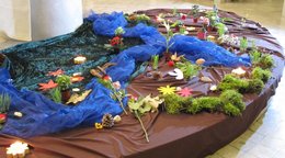 Blumen liegen auf einem mit einem blauen Tuch bedeckten Tisch.