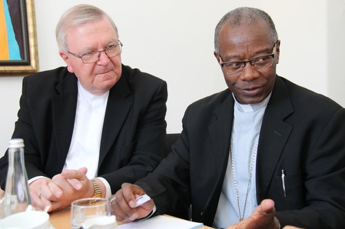 Weihbischof Georgens (links) mit Bischof Bimayemana aus Ruanda im Gespräch an einem Tisch.